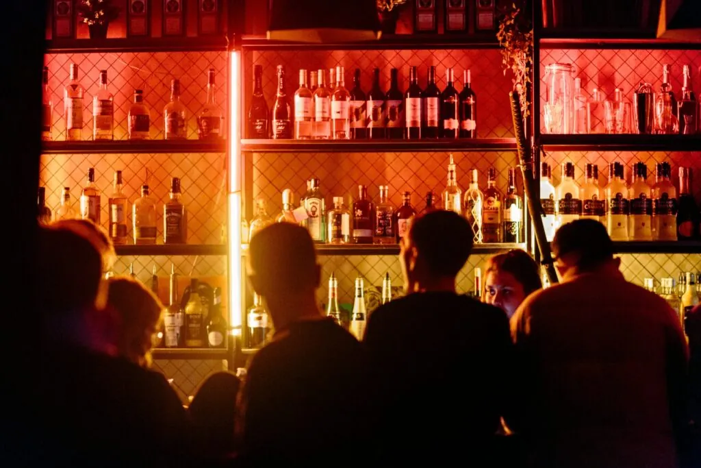 People around a bar at a nightclub.